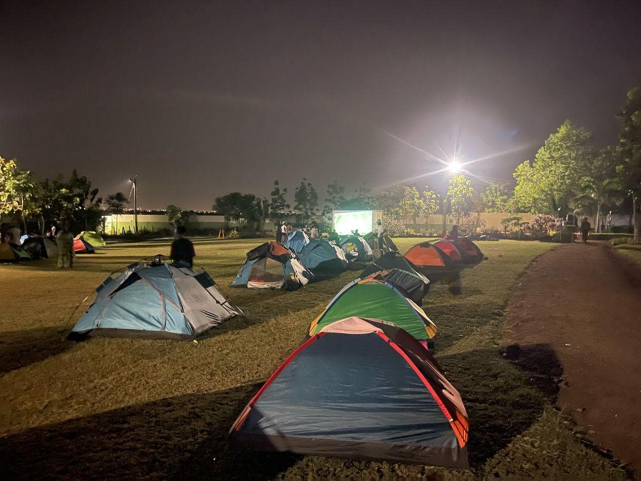 Tents at night with movie screen in background